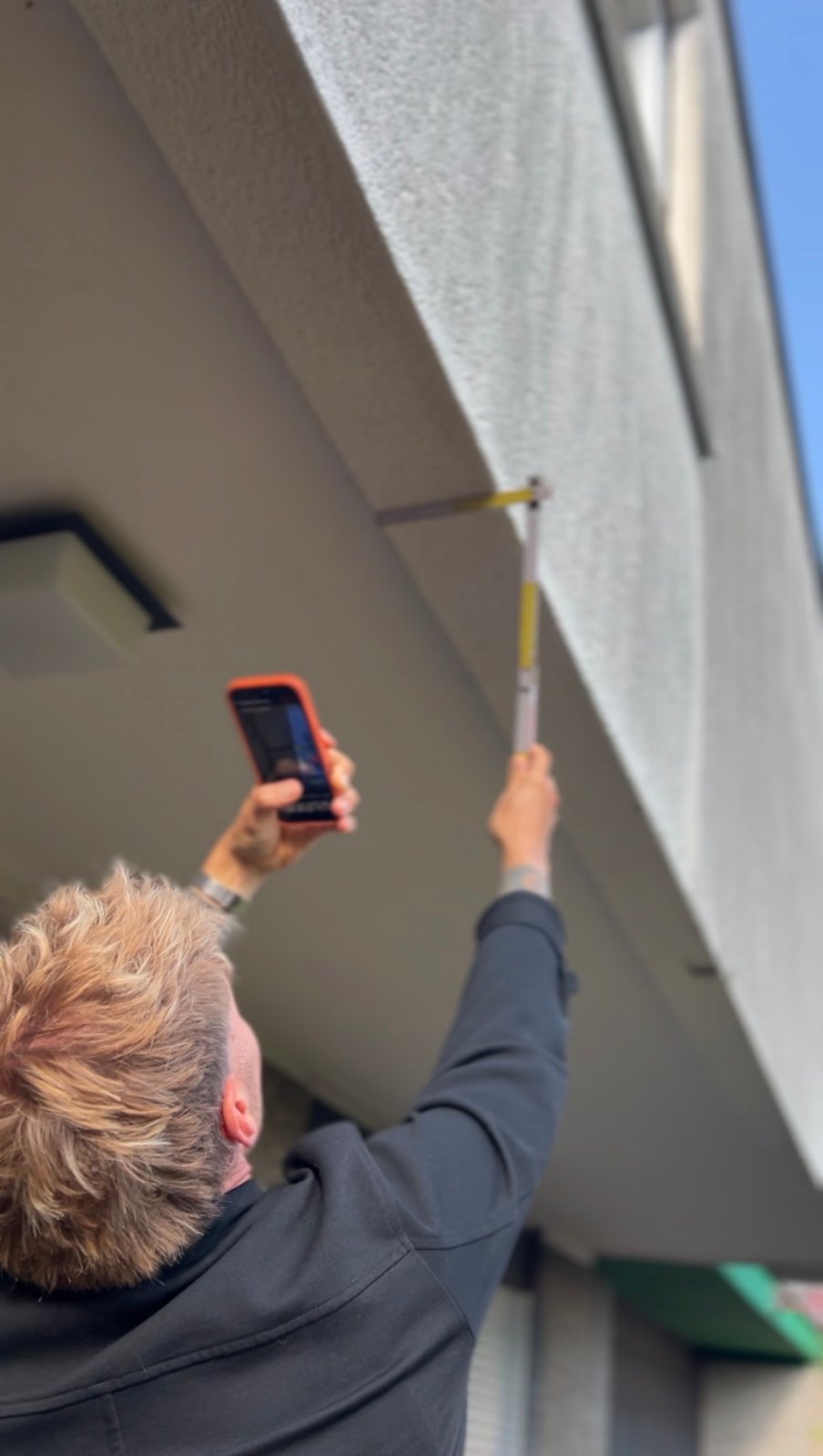 Messung an der Außenwand mit Zollstock und App